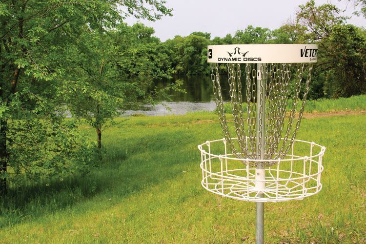 Disc Golf basket in front of lake